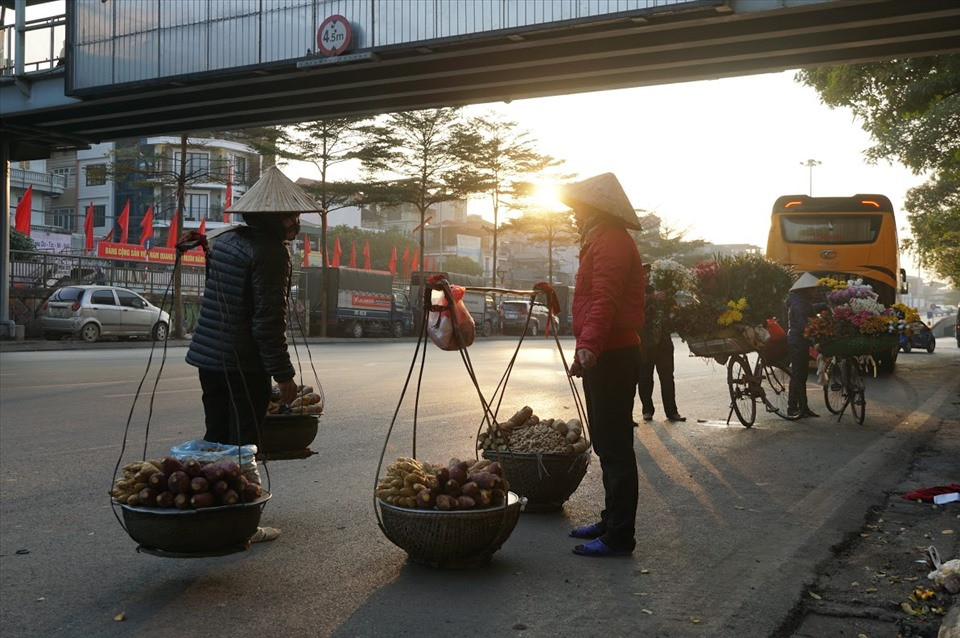Dưới những cung đường, những chiếc xe chở đầy hoa và cả những gánh hàng rong vẫn nhộn nhịp lạ thường.