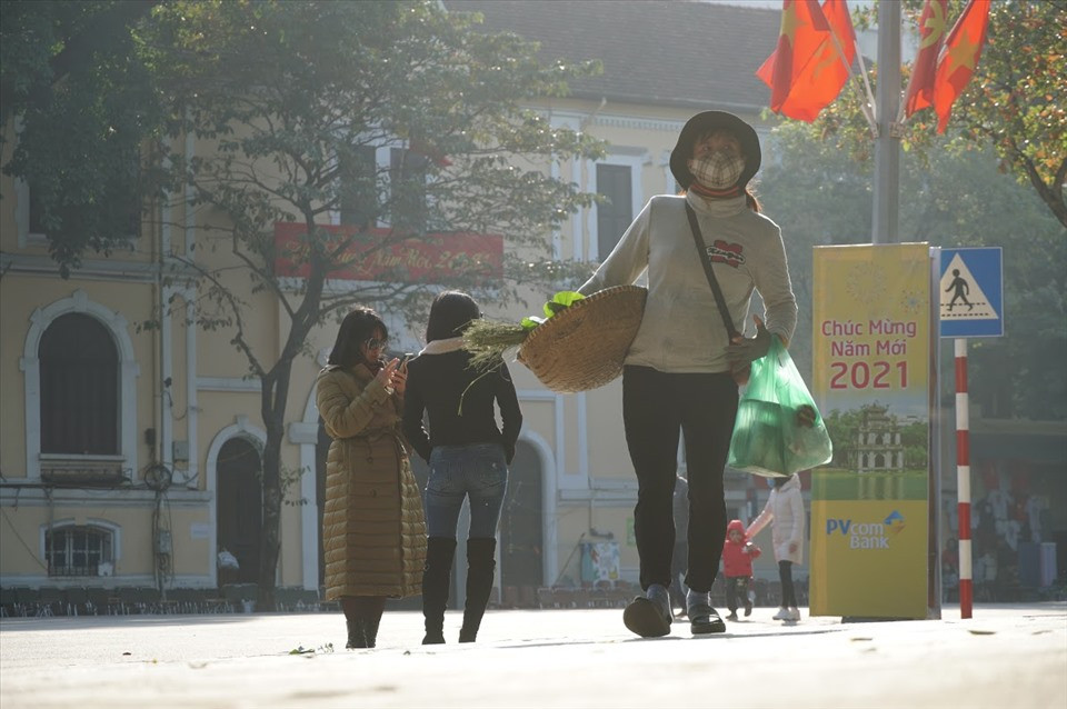 Trong khi người dân tấp nập đi chơi tết, người phụ nữ bán cốm miệt mài đi khắp ngõ ngách để bán chút hàng.