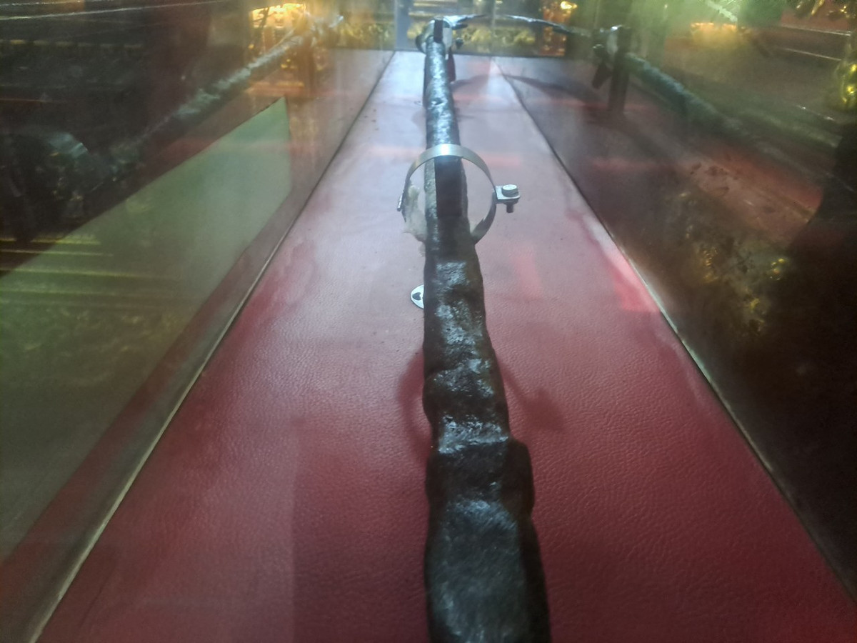 Long đao có mũi nhọn, lưỡi có hình tựa bán nguyệt, cán dài. Khâu đao tạo tác hình linh vật Nhai Tí: đầu giống rồng, thân có vẩy, miệng há rộng làm bệ đỡ lưỡi đao, răng nanh nhô ra ngoài, có mũi sư tử, trán lạc đà, mắt tròn to, tai hình quạt, từ hốc mắt toả ra hai bên râu đơn, cong, cuộn đầu; phía dưới (cổ) đúc nổi 4 râu tựa đao mác, hai râu giữa đan vắt chéo nhau, các râu bên roãng lượn sóng nhẹ. 