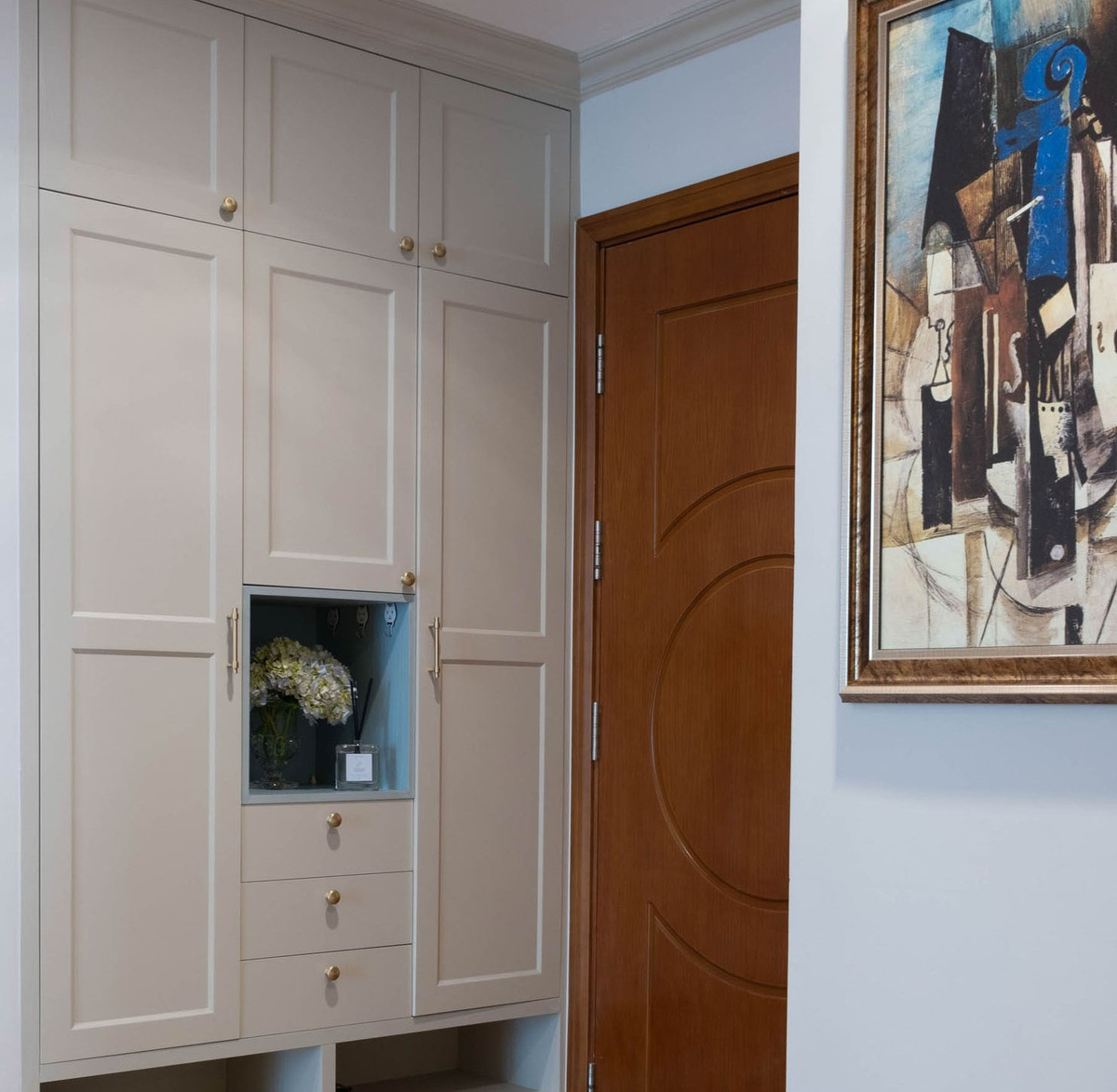 Cửa kính trượt sang hai bên tiết kiệm diện tích. Khung cửa bo góc cổ điển. Tủ giầy thiết kế đủ rộng để gia chủ có thể đặt cả áo mưa, mũ bảo hiểm và những đồ lặt vặt cho không gian tiếp đón thật gọn gàng. 