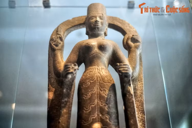 Bức tượng này được tạc từ đá sa thạch, có chiều cao 75 cm, ngang 32,3 cm, nặng 75 kg, có niên đại vào khoảng thế kỷ 7 – 8. Hiện vật thể hiện hình ảnh một nữ nhân đầu đội mũ trụ, ngực để trần, có bốn tay đứng trên bệ liền với một vòng cung đỡ ở phía sau.