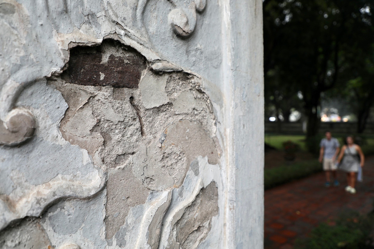 4 trụ gạch vuông tại tầng 1 được chạm trổ các hoa văn đã bị bong tróc lớp áo.