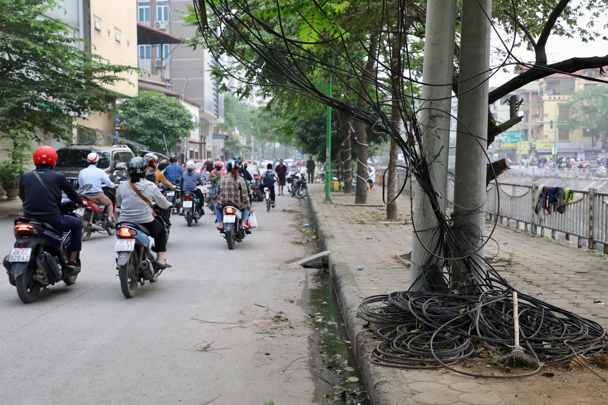 Tại phố Hà Kế Tân (quận Thanh Xuân), những cuộn dây cáp viễn thông để lộ thiên trên đường, chiếm gần hết vỉa hè của người đi bộ.
