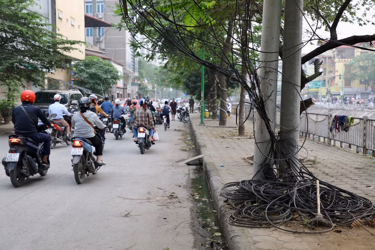 Tại phố Hà Kế Tân (quận Thanh Xuân), những cuộn dây cáp viễn thông để lộ thiên trên đường, chiếm gần hết vỉa hè của người đi bộ.