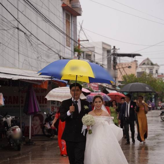 Buổi sáng 27/9, bão vẫn chưa có ảnh hưởng lớn vào đất liền, thời tiết dù xuất hiện mưa nhưng cũng không gây quá nhiều cản trở, hai gia đình vẫn quyết định tổ chức hôn lễ nhưng đẩy nhanh mọi tiến độ để "chạy Noru". Ảnh: Pháp Luật Online