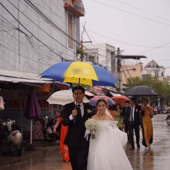 Buổi sáng 27/9, bão vẫn chưa có ảnh hưởng lớn vào đất liền, thời tiết dù xuất hiện mưa nhưng cũng không gây quá nhiều cản trở, hai gia đình vẫn quyết định tổ chức hôn lễ nhưng đẩy nhanh mọi tiến độ để "chạy Noru". Ảnh: Pháp Luật Online