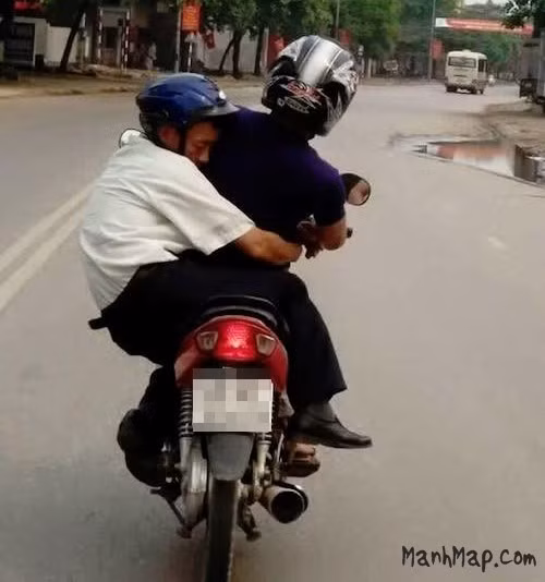 Trái ngược với hình ảnh trên là cảnh tượng bà vợ phải oằn mình giữ thăng bằng cho xe máy để đưa chồng về an toàn.