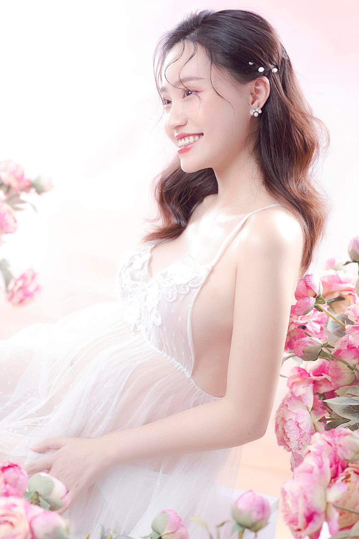 Trong ảnh, MC Xuân Anh diện đầm trắng quyến rũ, mái tóc buông xõa nhẹ nhàng, trang điểm tông hồng nữ tính.