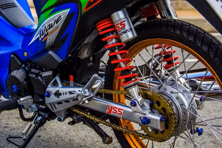 Bộ gắp sau của chiếc xe cũng đã được thay bằng gắp nhôm nhẹ và cứng cáp hơn, trong khi hệ thống phuộc YSS khiến chiếc Wave ổn định hơn trên đường. Bộ nhông sên đĩa vàng tạo thêm điểm nhấn ở phía sau cho xe.