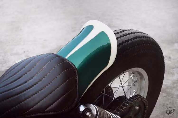 Dè sau của chiếc xe cũng đã được cắt ngắn, sau đó uốn nhẹ ở phía cuối theo kiểu dáng bobber. Cũng giống như bình xăng, dè sau đã được sơn màu xanh kết hợp cùng chỉ trắng tinh tế, nằm phía trên là chiếc yên solo "siêu mỏng".