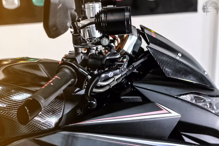 Ngoài ra, trên tay lái cũng đã được gắn thêm một số món đồ chơi "hàng hiệu" như tay phanh Brembo, gù xéo Rizoma, bao tay Domino và cặp bình dầu nhôm Rizoma.