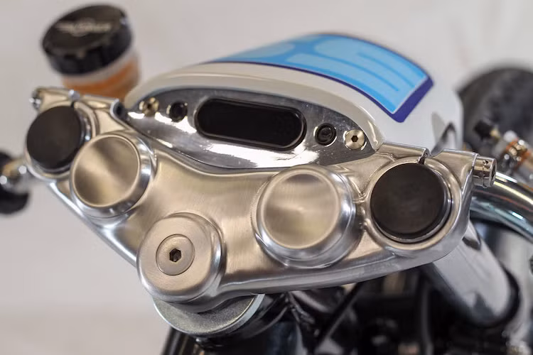 Để đem tới cho chiếc SR400 tư thế của một chiếc cafe racer, Krugger đã hạ thấp chảng ba của chiếc xe xuống. Trước khi hạ, anh cũng không quên đánh bóng nó. Ở phía trên chảng ba là một đồng hồ điện tử siêu gọn từ Motogadget, và hãng phụ kiện Đức này cũng đã cung cấp bộ cùm công tắc rút gọn cho chiếc xe.