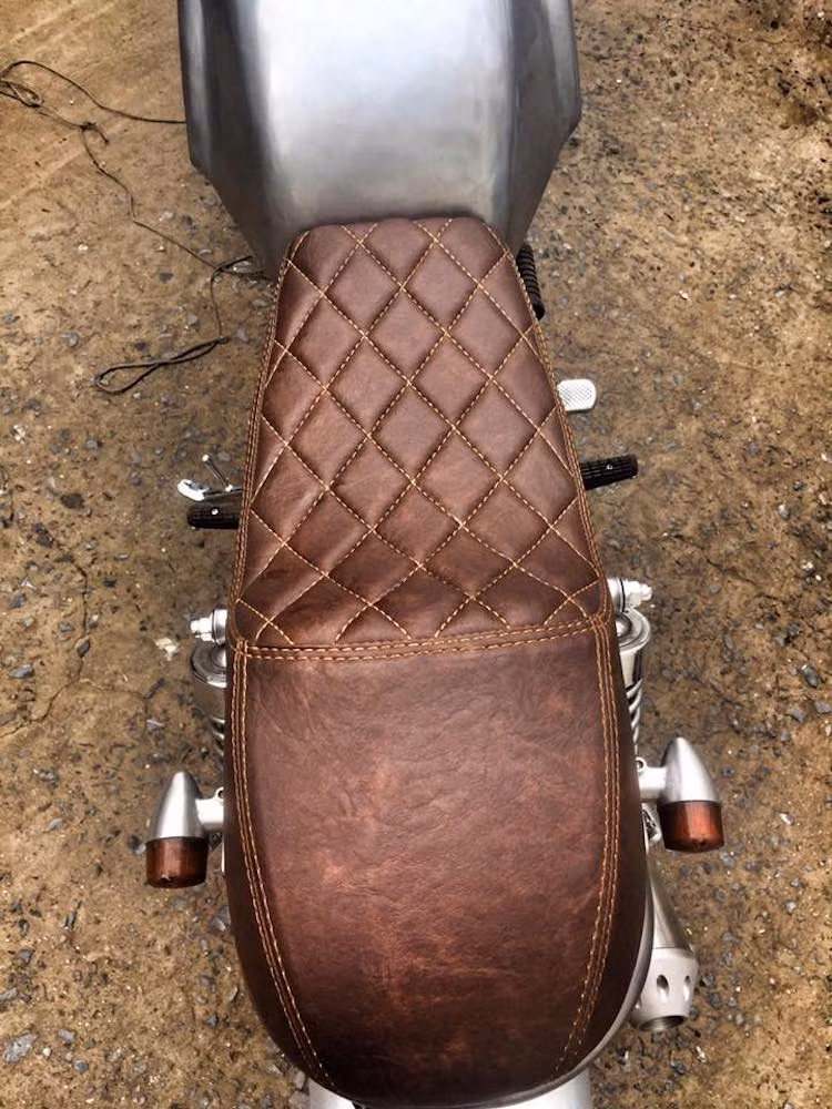 Bộ yên phía sau cũng đã được làm lại hoàn toàn với phần mút dày đằng sau tạo thành một "gò" theo đúng phong cách cafe racer. Sau đó, yên xe được bọc trong da nâu và chần chỉ đầy nam tính.