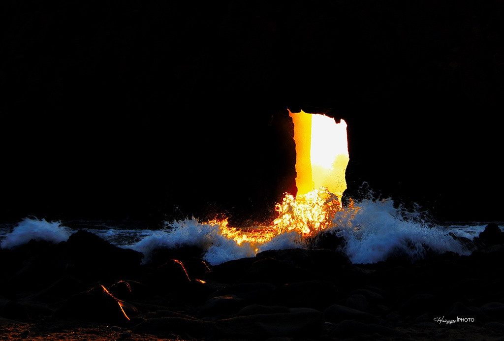 Trước và sau ngày Đông chí khoảng một tuần, lúc hoàng hôn, Mặt Trời từ từ hạ xuống biển, ánh nắng xuyên qua đường hầm, chiếu lên bọt sóng đập vào những tảng đá ven bờ tạo nên những ánh sao bắn tung tóe lên trời, những hạt nước li ti như tấm màn chứa sáng nghiêng nghiêng trước cửa hang. Ảnh: Hai Nguyễn.