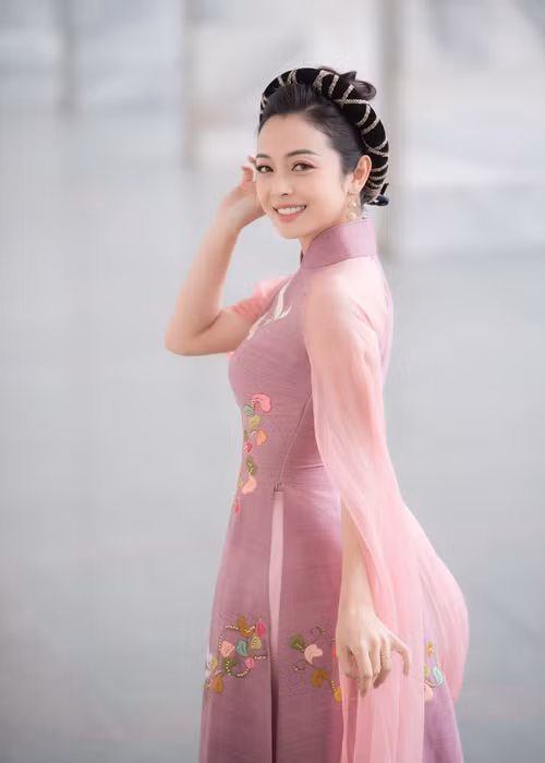 Mẫu áo dài cách tân có gam màu trầm nhã nhặn mang đến nét duyên dáng, thùy mị cho Hoa hậu Jennifer Phạm.