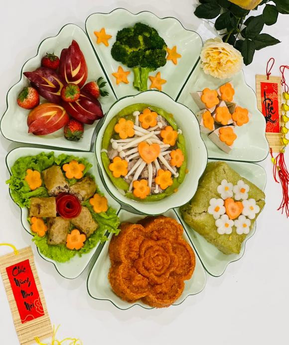 Bà xã của nghệ sĩ Công Lý làm mâm cúng ông Công ông Táo sớm. Mâm cỗ cúng của gia đình Công Lý gồm xôi gấc, bánh chưng, nem rán, giò, súp lơ luộc, canh.