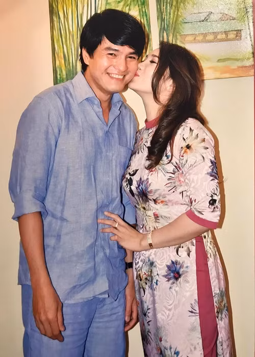 Cao Minh Đạt cười tít mắt khi được bà xã hôn má.