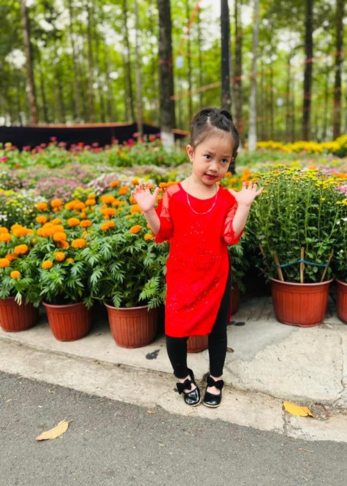 Bảo Nhi - con gái của Lê Dương Bảo Lâm diện áo dài đỏ đi chợ hoa. Ảnh: Yan