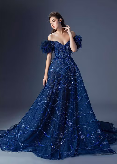 Trong bộ đầm dạ hội xanh đính cườm trễ vai, Tường San khéo khoe vòng một gợi cảm.