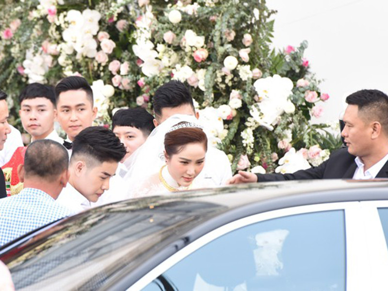 Bảo Thy mặc váy cưới trắng, di chuyển từ nhà riêng ra xe rước dâu. Ảnh: Zing