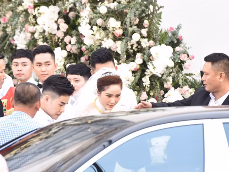 Bảo Thy mặc váy cưới trắng, di chuyển từ nhà riêng ra xe rước dâu. Ảnh: Zing