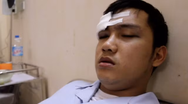 Sau khi được điều dưỡng đưa bệnh nhân vào buồng bệnh và cặp nhiệt độ, bác sĩ Nguyễn Đình Phi thăm khám, bất ngờ từ phía sau có tiếng chửi bới, một người đàn ông xưng là cha cháu Đạt xông đến túm cổ áo bác sĩ Phi, đấm thẳng vào mặt, làm bác sĩ bị vỡ kính, choáng váng ngã xuống sàn nhà.