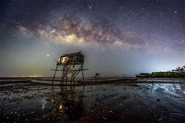 Anh Chu Thiện Sơn (TP. HCM) cho biết lần đầu tiên đi chụp Dải Ngân Hà cùng với bạn bè là tại bãi biển Tân Thành, Tiền Giang với tiền cảnh là chòi canh ngêu của ngư dân.