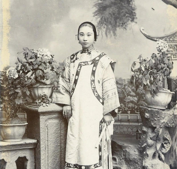 Hình ảnh của một cô gái xuất thân quyền quý. Mặc dù được chụp trong phòng chụp ảnh nhưng bối cảnh lại sắp xếp phức tạp, tạo cảm giác như một khu vườn thật. Những họa tiết thêu trên trang phục của cô rất tinh tế, thể hiện khả năng tài chính gia đình rất tốt.