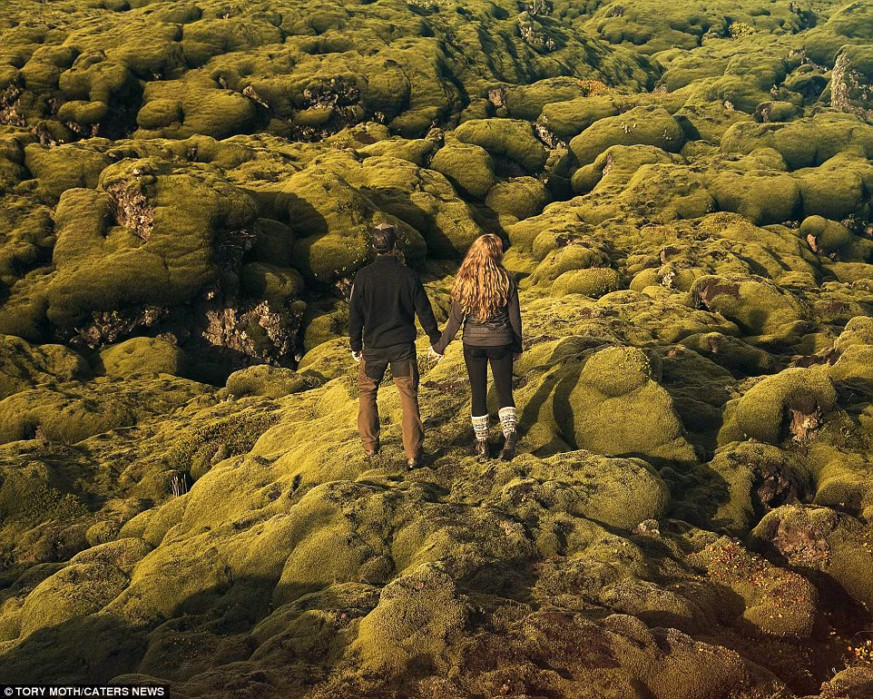 Nắm tay nhau đứng trên những tảng đá phủ đầy rêu xanh.