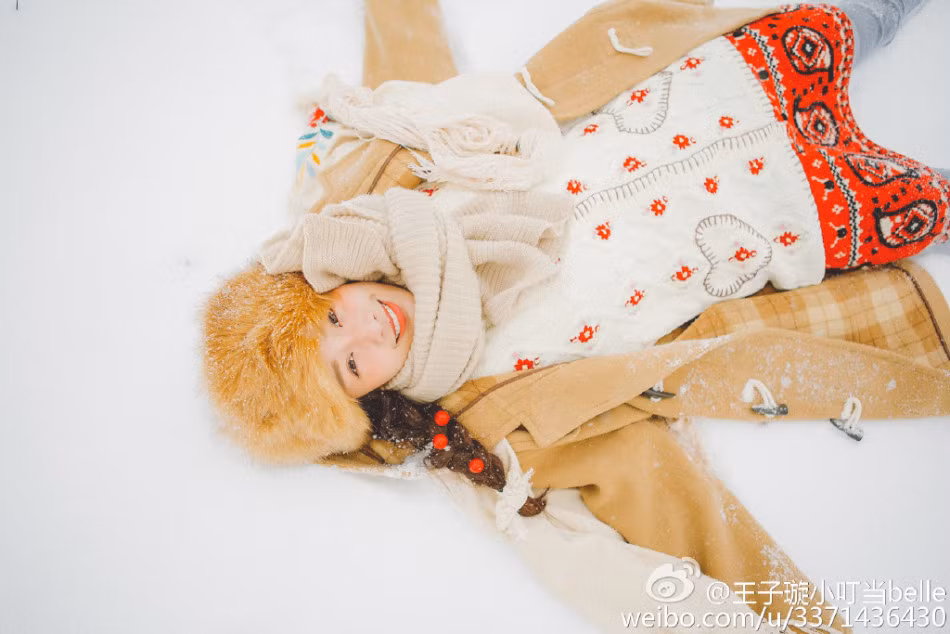 Người đẹp vui đùa với tuyết trắng.