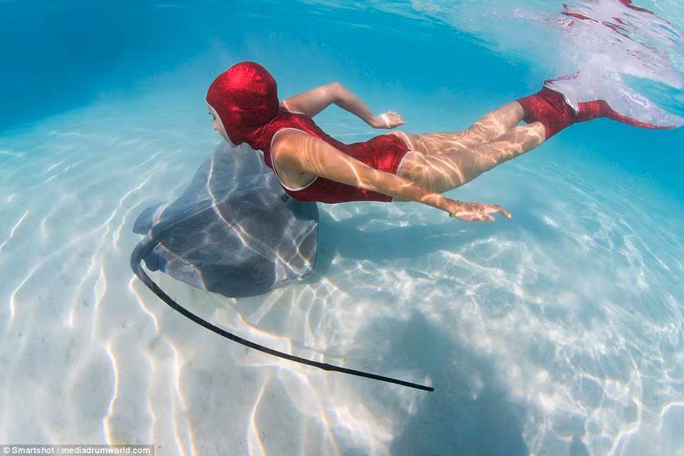 Người mẫu và cá đuối lượn lờ quanh nhau như đôi bạn thân.