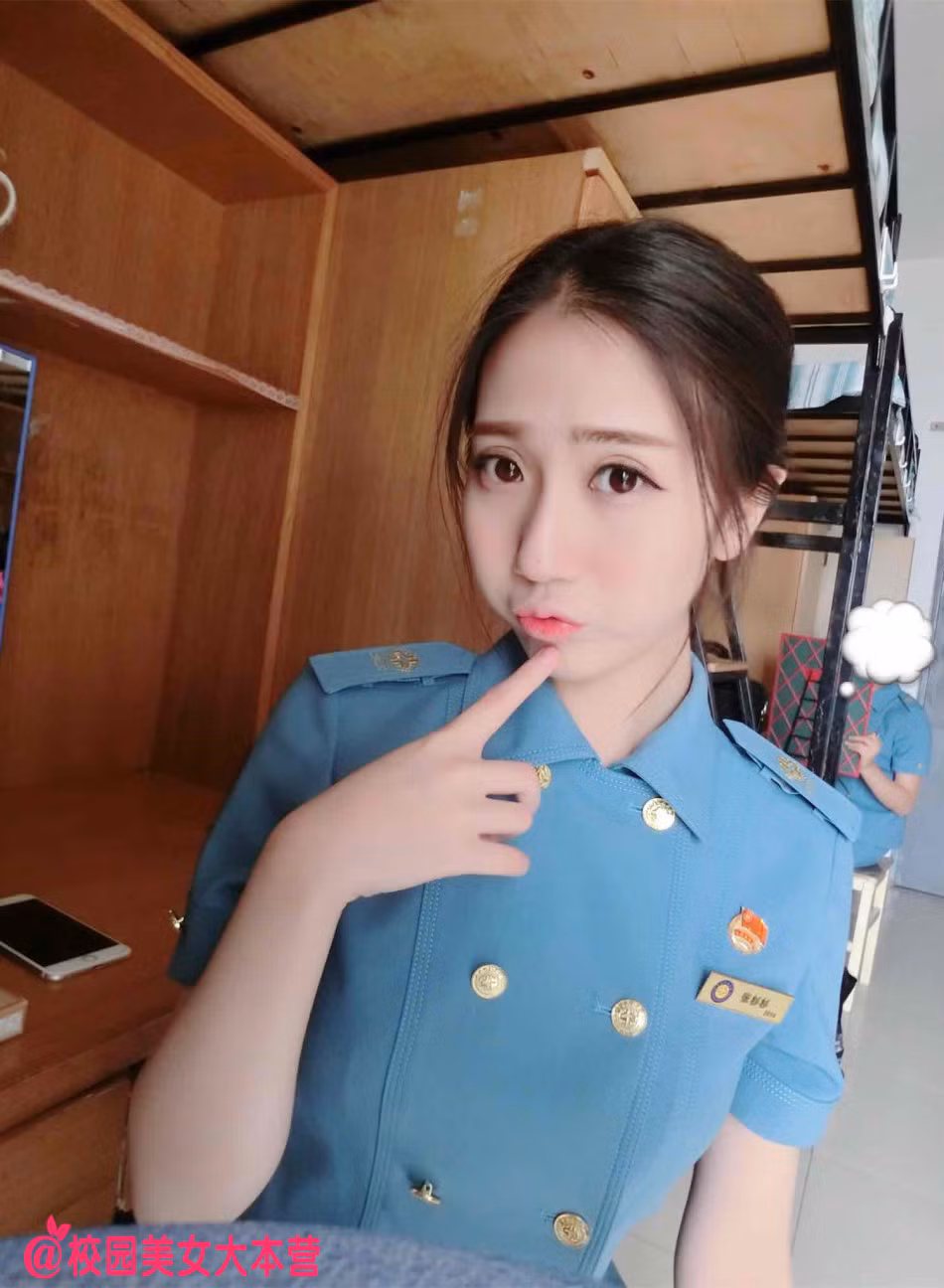 Zhang chụp ảnh tại ký túc xá trong bộ đồng phục màu xanh.