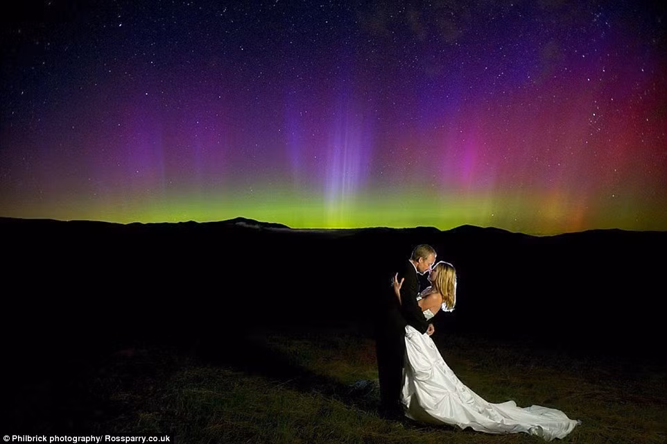 Sulkoski và Kevin Coleman hôn nhau lãng mạn trên nền ánh sáng bắc cực quang tuyệt đẹp.