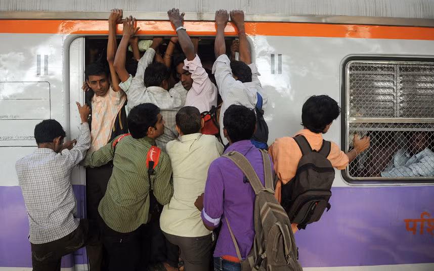Mọi người chen chúc lên một chuyến tàu đông đúc ở thành phố Mumbai, Ấn Độ.
