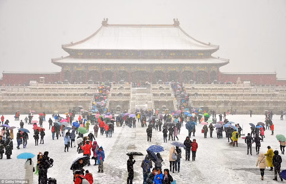 Du khách thích thú chụp ảnh với tuyết rơi tại khu Tử Cấm Thành ở Bắc Kinh.