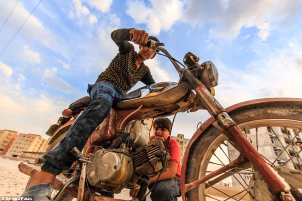 Hai cậu bé cố gắng sửa một chiếc mô tô chết máy ở ngoại ô thành phố Kerman.