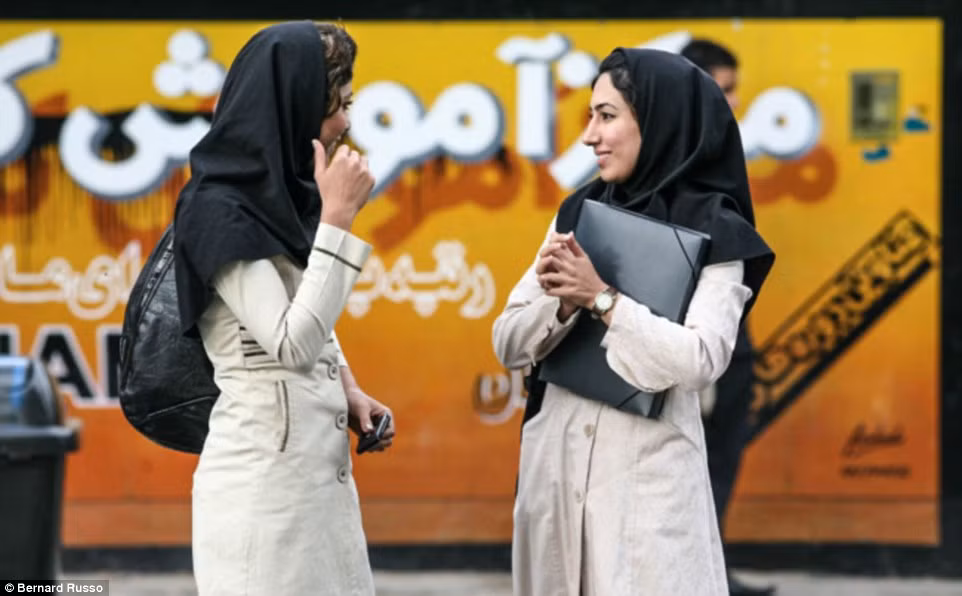 Hai nữ sinh đứng nói chuyện bên ngoài một trường ngoại ngữ ở Shiraz.