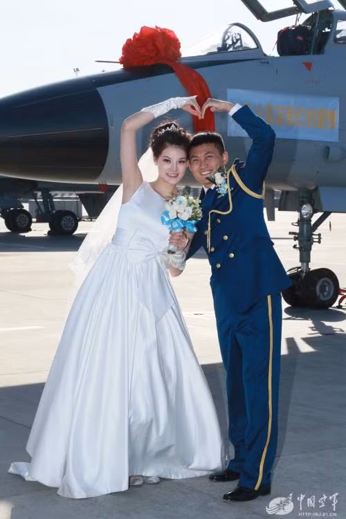 Một cặp đôi chụp ảnh kỷ niệm trước chiến đấu cơ.