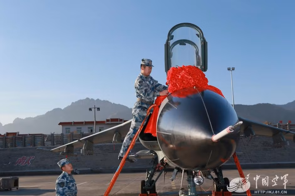 Binh sĩ buộc ruy băng đỏ quanh chiến đấu cơ để chuẩn bị cho đám cưới tập thể tại căn cứ không quân trên Thiên Sơn ở thành phố Lan Châu, Trung Quốc.