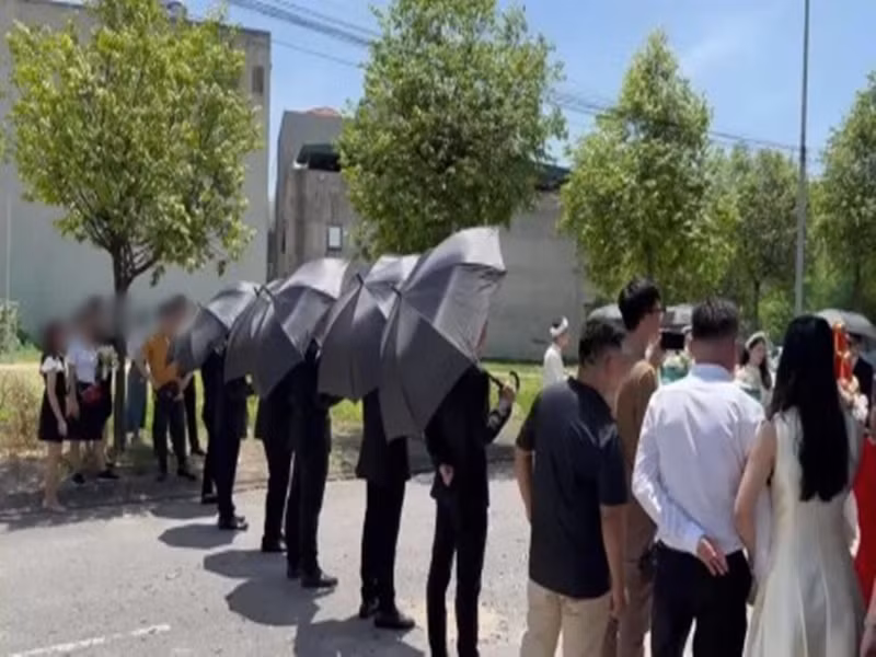 Dàn vệ sĩ dùng ô che chắn không gian đám hỏi. Ảnh: Arttimes.