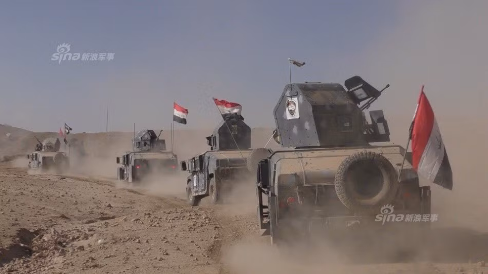 Các binh sĩ Quân đội Iraq hành quân với xe bọc thép Humvee.