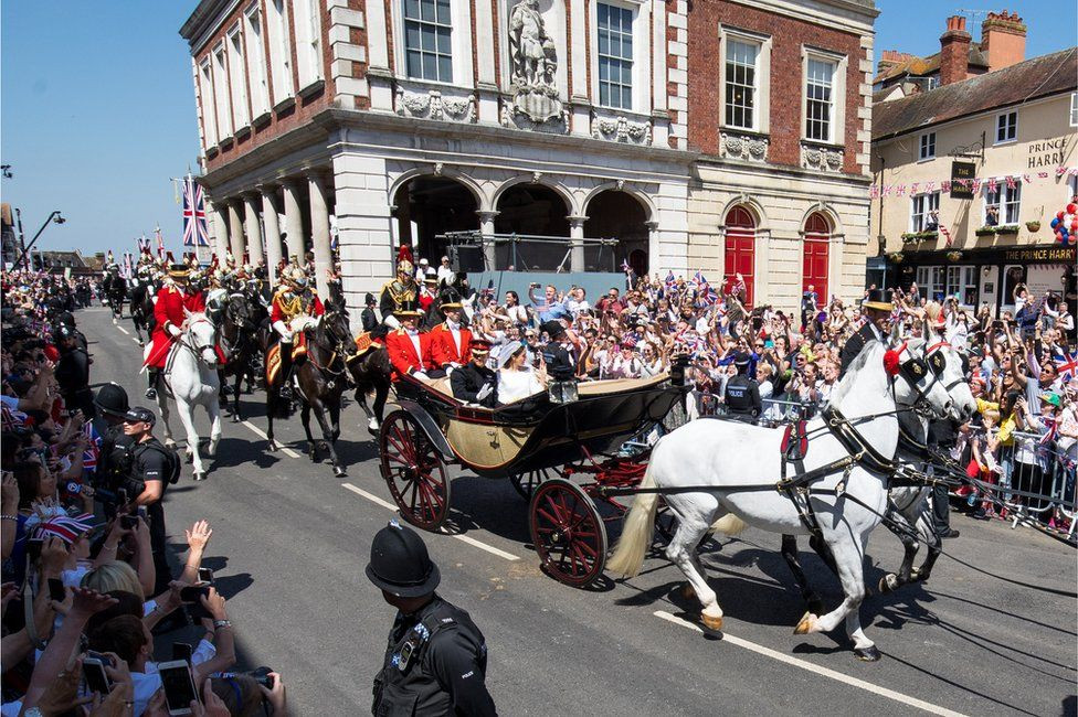 Khi ấy, các thành viên của trung đoàn Household Cavalry cưỡi ngựa và hộ tống xe ngựa đưa Hoàng tử Harry và nữ diễn viên Meghan Markle diễu hành từ lễ đường St. George, qua lâu đài Windsor, đi xuyên qua các con phố để vẫy chào dân Anh trước khi trở lại công viên bên trong lâu đài.