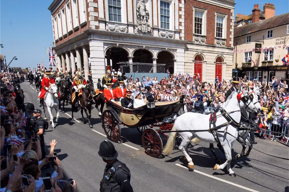 Khi ấy, các thành viên của trung đoàn Household Cavalry cưỡi ngựa và hộ tống xe ngựa đưa Hoàng tử Harry và nữ diễn viên Meghan Markle diễu hành từ lễ đường St. George, qua lâu đài Windsor, đi xuyên qua các con phố để vẫy chào dân Anh trước khi trở lại công viên bên trong lâu đài.