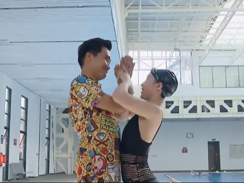 Trong buổi học bơi tiếp theo, Bách giả vờ bị đuối nước khiến cô giáo dạy bơi lao xuống cứu. "Từ ngày hôm nay tôi quyết định sẽ cách chức cô giáo, thăng chức cô giáo lên chức mới - chức người yêu anh", Bách tỏ tình. Ảnh: VTV