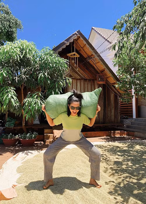 Nàng hoa hậu vừa phơi thóc vừa rèn thể lực bằng cách vác bao thóc.