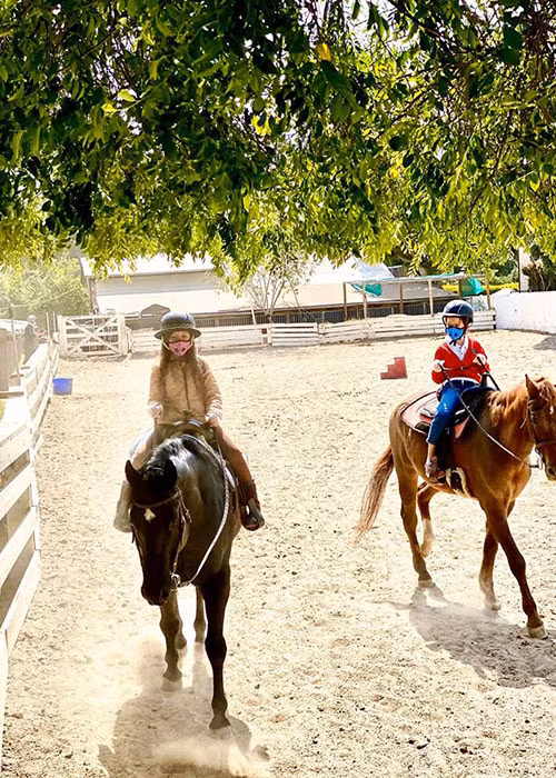 Tôm và Tép được mẹ đưa đi học cưỡi ngựa. Để phòng tránh COVID-19, cả hai đeo khẩu trang và găng tay.