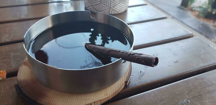 Đồ uống trong một chiếc gạt tàn, có tặng thêm điếu thuốc bằng sô cô la.