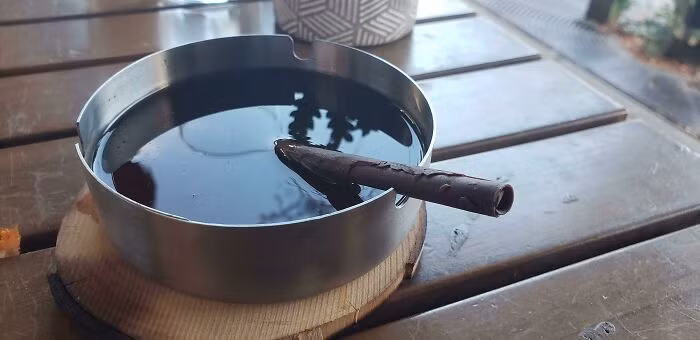 Đồ uống trong một chiếc gạt tàn, có tặng thêm điếu thuốc bằng sô cô la.