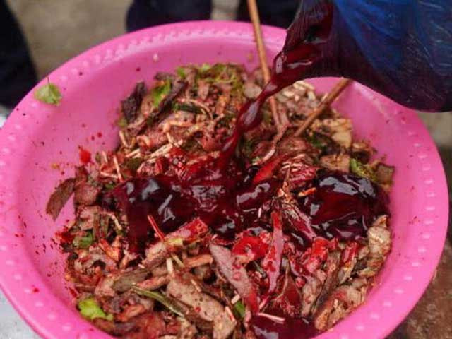 Vì ăn cùng nước sốt làm từ tiết canh lợn nên món ăn còn được gọi là "thịt đỏ trộn tiết"