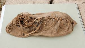 Chiếc giày được làm từ da bò, được ghép từ các mảnh da riêng và được tạo hình phù hợp với bàn chân của người đi.